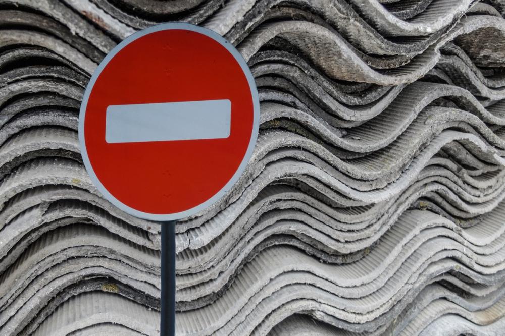 A no-entry sign in front of old asbestos products 