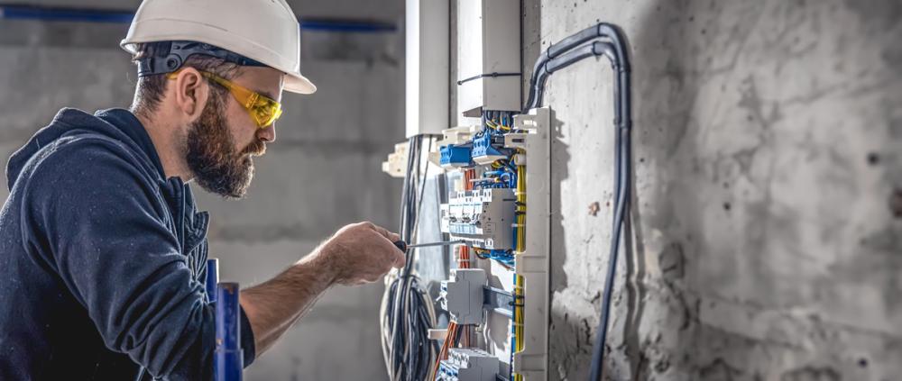 A male electrician working on a switchboard