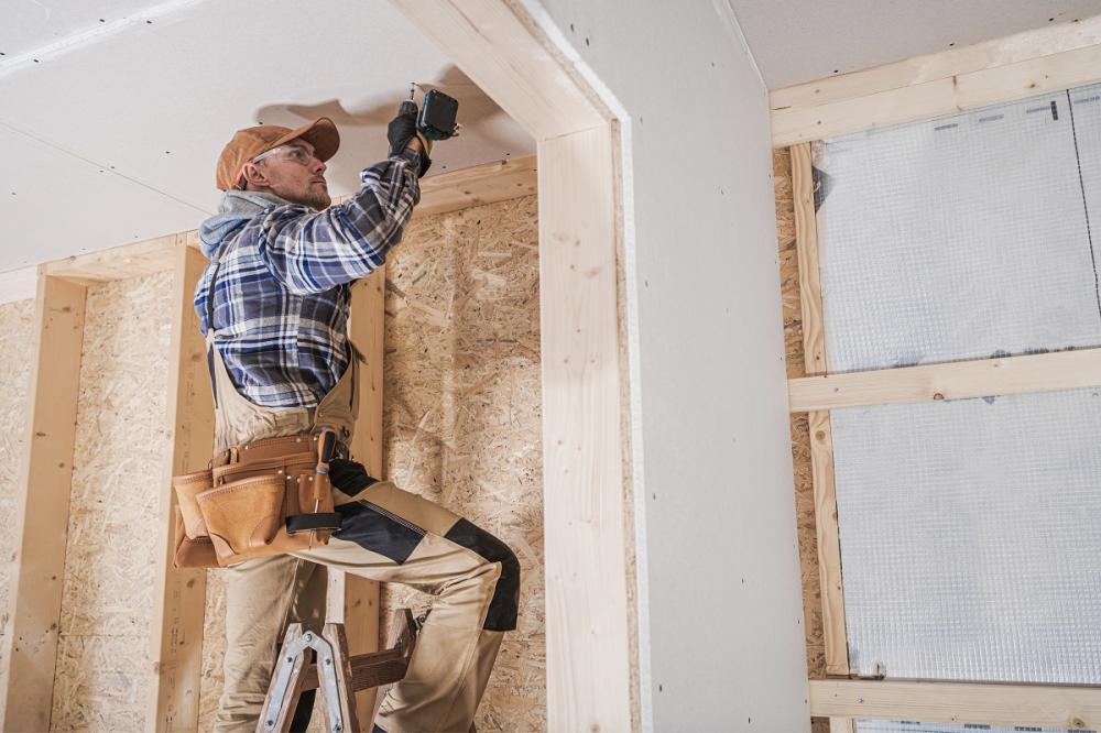 Man attaching drywall to the ceiling