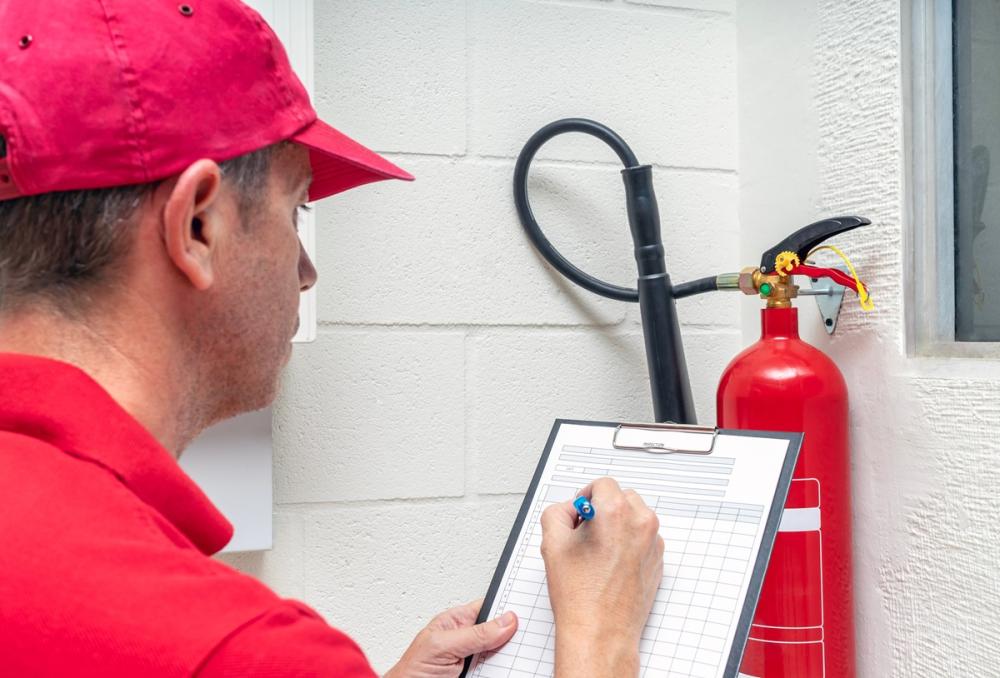 Technician performing an inspection of a carbon dioxide fire extinguisher