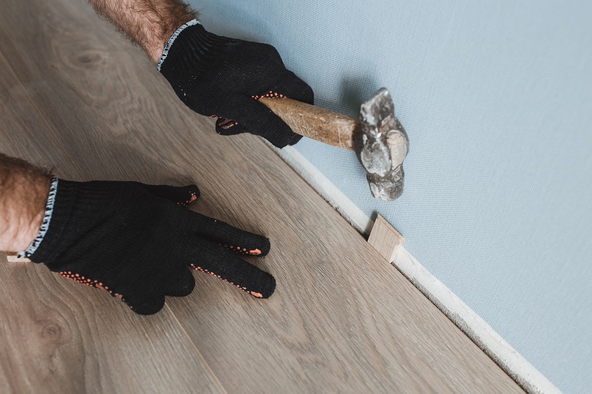 Person leaving an expansion gap in laminate flooring