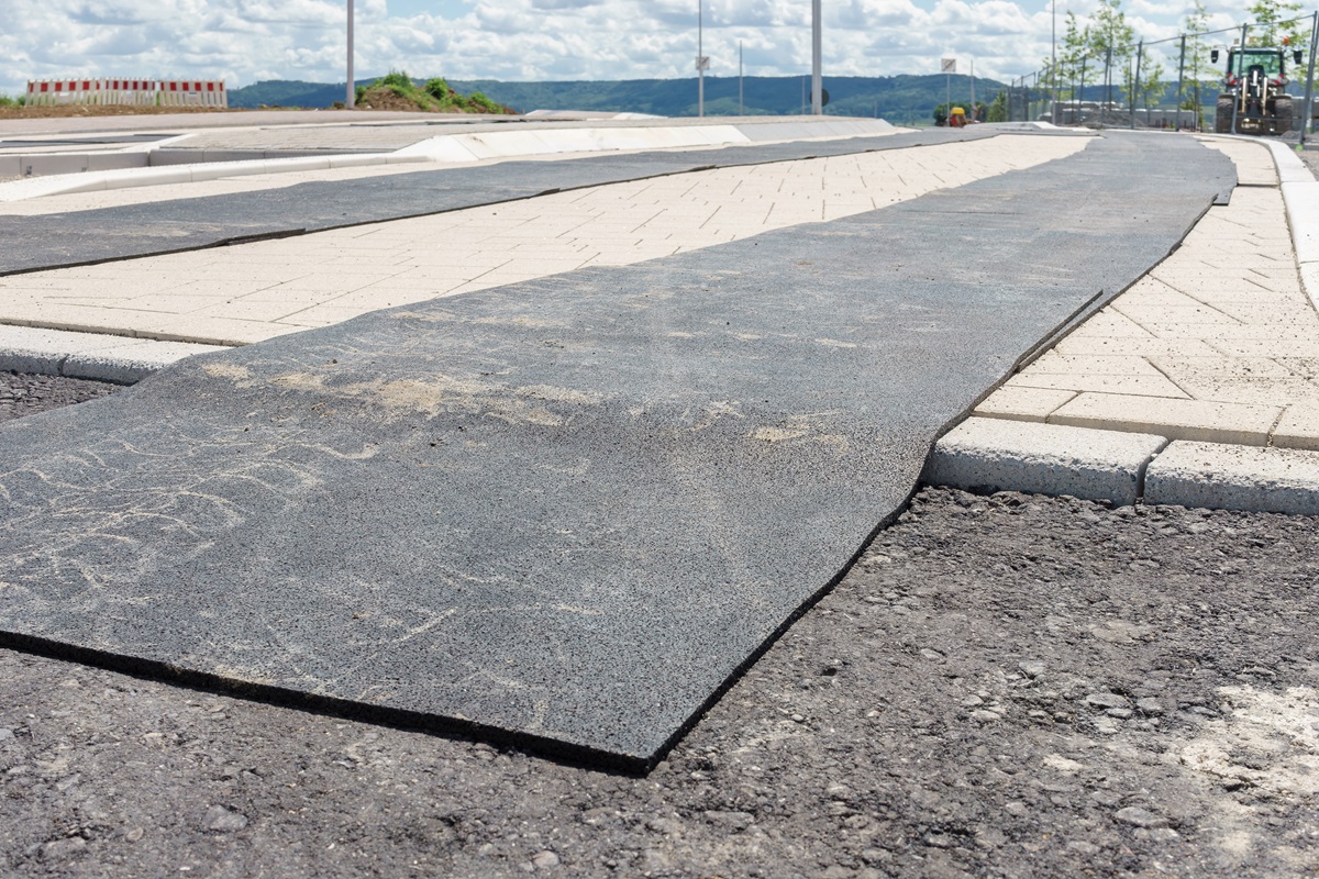 Protective mat over newly laid paving